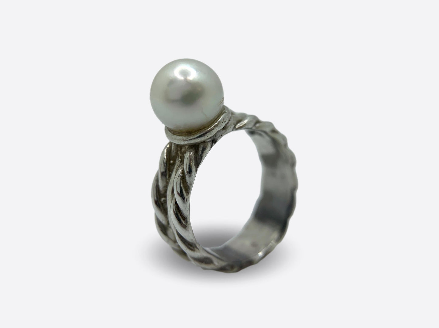 Anello artigianale con fascia lavorata in argento e perla bianca.